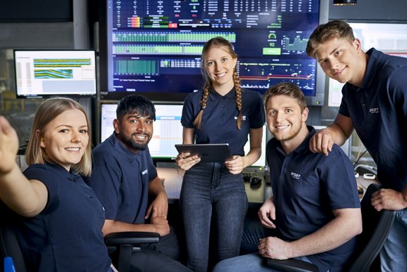 Gruppe von jungen Menschen im BENTELER T-shirt vor einem Bildschirm von Daten
